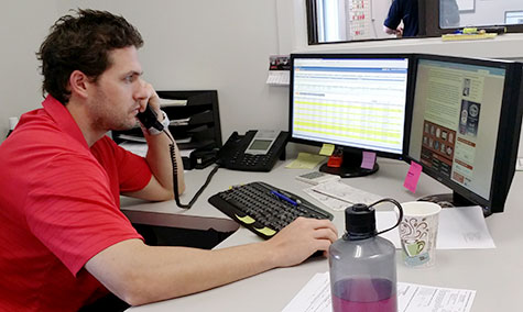 man in red shirt talking on phone